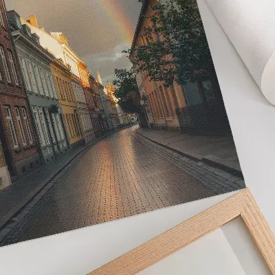 Plakat na płótnie kolorowe kamienice z tęczą na tle pochmurnego nieba