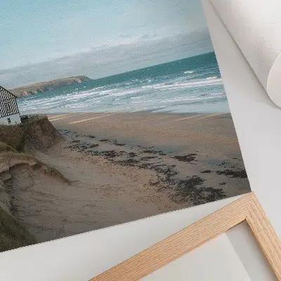 Plakat na płótnie plaża z falami i domem na klifie w pastelowych barwach