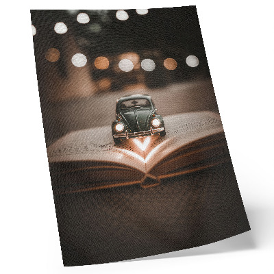 Plakat ścienny Miniaturowy samochód na książce magiczne światła